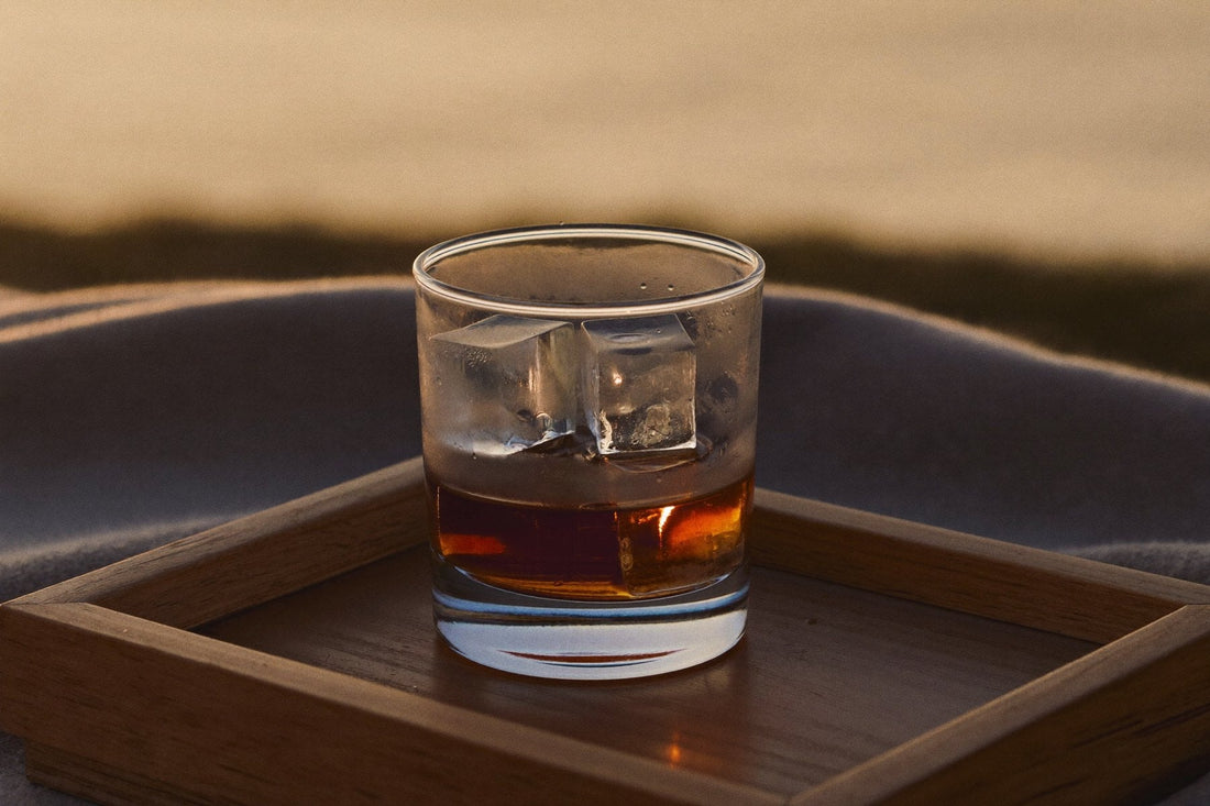 Glas med iskuber på en bricka i trä